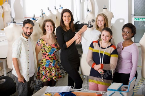 Aperçu: A Fashion Design Lecturer Posing With Her Students Around A Mannequin In A University Classroom.