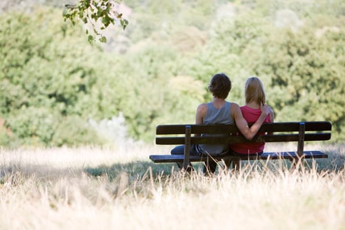 Preview: A Young Couple Sitting On A Bench In A Park