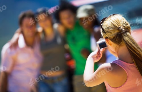 Preview: Woman Taking Photo Of Young Friends On Road Trip By Car In Countryside