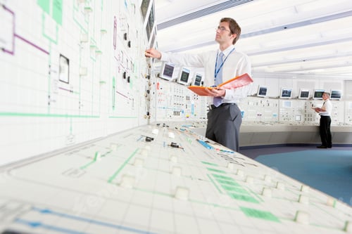 Preview: Low-Angle Shot Of A Young Engineer With A File Adjusting Controls While Looking At A Computer