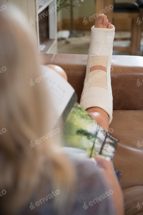 Preview: Close Up Of Mature Woman With Leg In Plaster Cast Lying On Sofa At Home