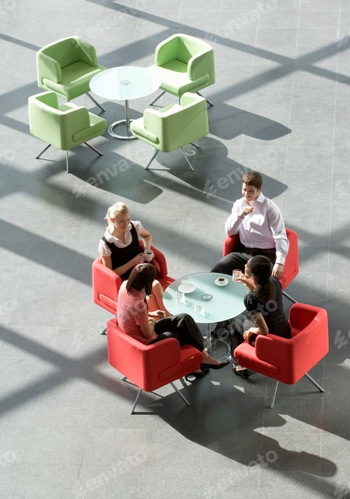 Preview: Four Business Colleagues Holding A Meeting Having A Drink