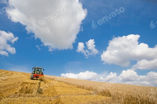 Preview: Wide Shot Of A Tractor Arranging Straw Bales In A Rural Field On A Sunny Day.