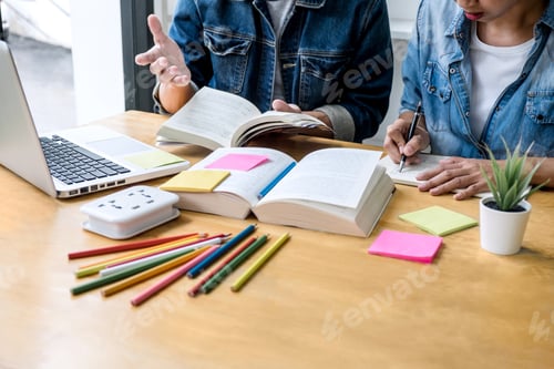 Preview: High School Tutor Or College Student Group Sitting At Desk In Library Studying And Reading, Doing