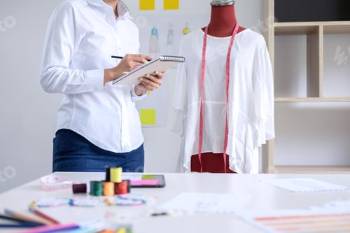 Preview: Stylish Fashion Designer Working With Measure Red Dummy As Sketches In Draft Book Of New Collection