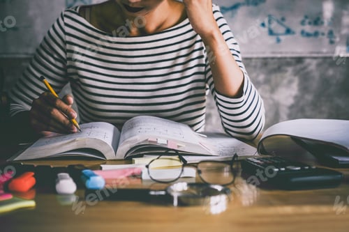 Preview: Young Student Sitting At Desk In Home Studying And Reading, Doing Homework And Lesson Practice