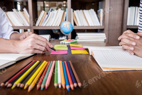 Preview: High School Or College Student Group Sitting At Desk In Library Studying And Reading, Doing