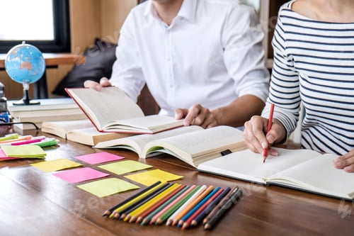 Preview: High School Or College Student Group Sitting At Desk In Library Studying And Reading, Doing