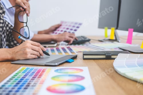 Preview: Two Colleagues Creative Graphic Designer Working On Color Selection And Drawing On Graphics Tablet