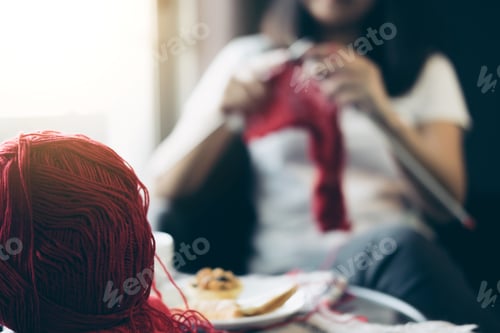 Preview: Close Up Shot Of Young Woman Hands Knitting A Red Scarf Handicraft In The Living Room On Terrace At