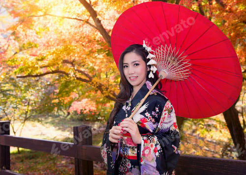 Preview: Asian Woman Wearing Traditional Japanese Kimono With Red Umbrella In Autumn.