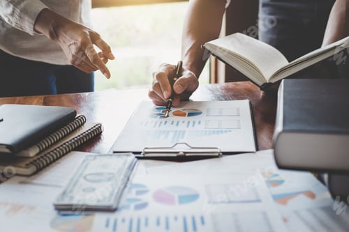 Preview: Team Discussing Financial Charts and Graphs in Office
