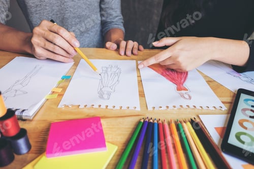 Preview: Two Young Dressmaker Or Designer Colleagues Working As Fashion Designers And Drawing Sketches For