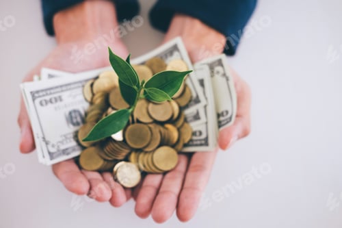 Preview: Hands Of Businessman Holding With Plant Sprouting Growing From A Handful Of Golden Coins And