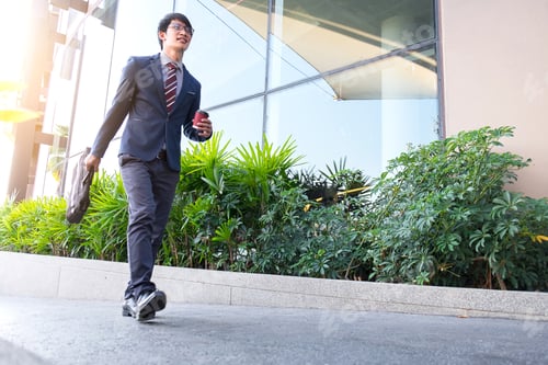 Preview: Picture Of A Young Business Man Walking Forward With A Briefcase In One Of His Hands And Coffee Cup.
