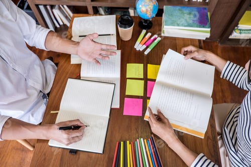 Preview: High School Or College Student Group Sitting At Desk In Library Studying And Reading, Doing