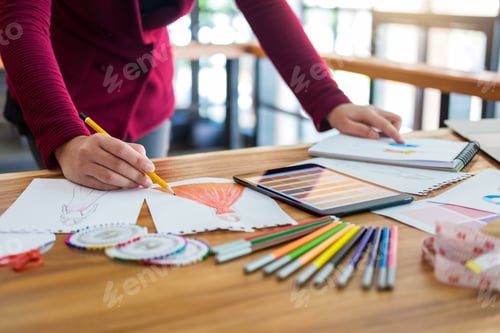 Preview: Young Woman Designer Working As Fashion Designers At Work With Fashion Sketches And Color Charts