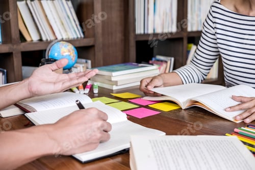 Preview: High School Or College Student Group Sitting At Desk In Library Studying And Reading, Doing