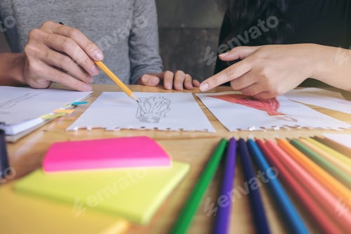 Preview: Two Young Dressmaker Or Designer Colleagues Working As Fashion Designers And Drawing Sketches For