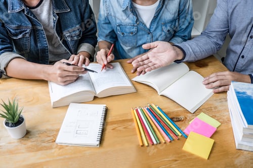 Preview: High School Or College Student Group Sitting At Desk In Library Studying And Reading, Doing
