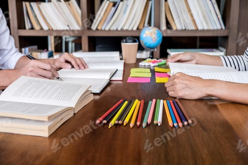 Preview: High School Or College Student Group Sitting At Desk In Library Studying And Reading, Doing