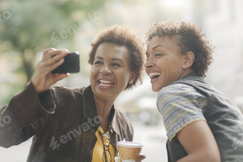 Preview: Two Mature Female Friends Taking Smartphone Selfie On Street