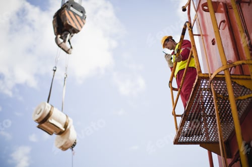 Preview: Worker Directing Crane On Oil Rig