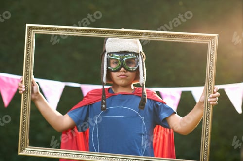 Preview: Portrait Of Boy Looking Through Picture Frame Wearing Cape, Goggles And Flying Hat