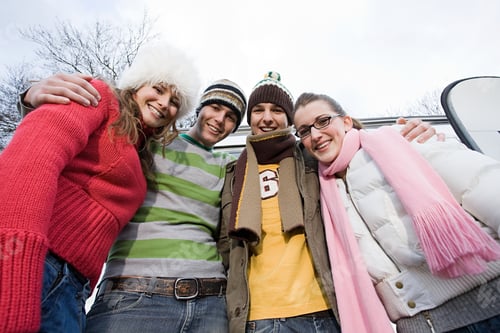 Preview: Four Young Adults Smiling Outdoors in Casual Clothing