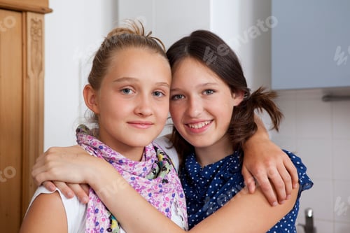 Smiling Teen Girls Embrace Indoors at Home