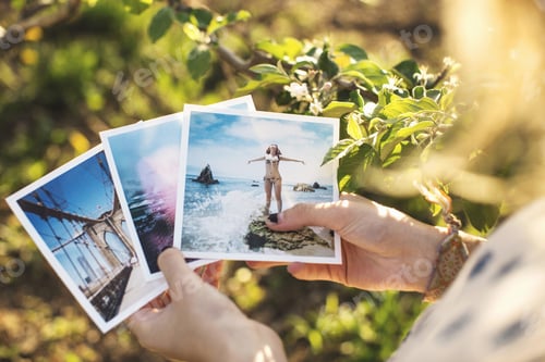 Preview: High Angle View Over Shoulder Of Young Woman Holding Photographs