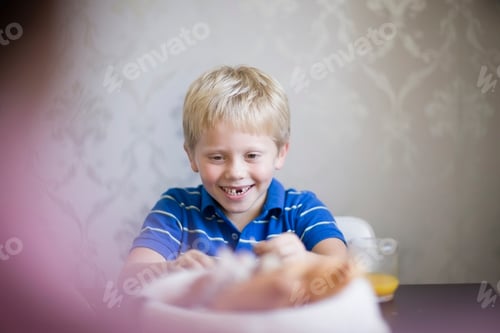 Visualização: Menino sorrindo na mesa de jantar