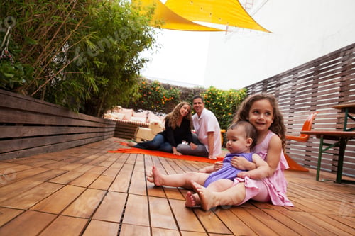 Preview: Girl With Baby Sister Sitting On Lap, Parents In Background