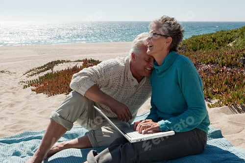 Preview: Mature Couple Using Laptop At The Beach