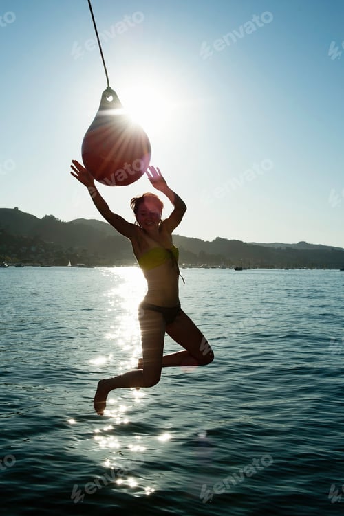 Preview: Young Woman Swinging From Boat Fender, Sausalito, California, Usa