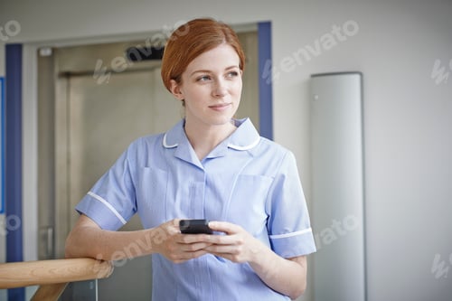 Preview: Female Nurse With Mobile Phone Outside Hospital Lift