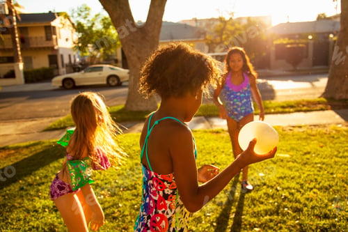 Preview: Three Girls Playing With Water Balloons In Garden