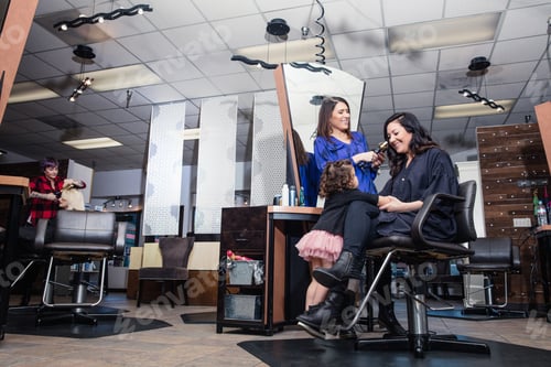 Hair Stylists Working With a Client And Child