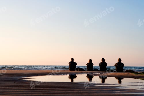 Preview: Four People Sitting On The Beach