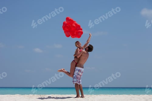 Visualização: Casal se abraçando com balões na praia