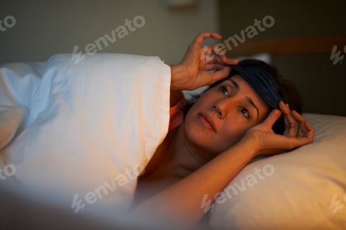 Preview: Mature Woman Putting On Eye Mask In Hotel Bed At Night