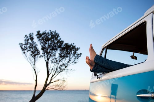 Preview: Feet Out Of Camper Van Window At Dusk