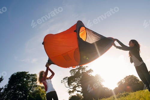 Preview: Teenage Girls Pitching Tent In Field