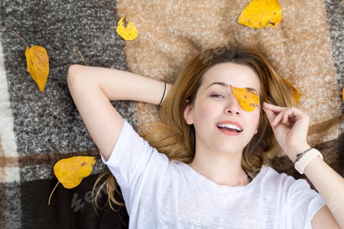 Preview: Young Woman Lying On Blanket, Covering Eye With Leaf