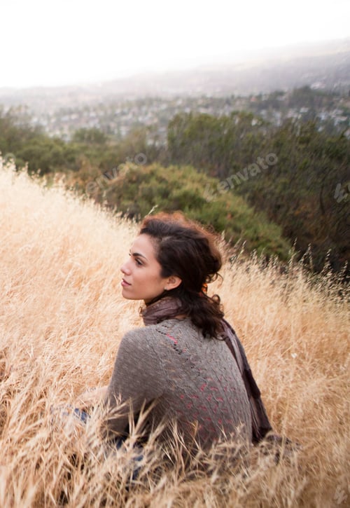 Preview: Young Woman Sitting Gazing From Long Grass