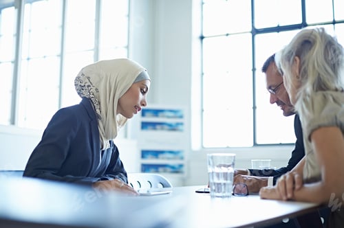 Preview: Two Businesswomen And Man Looking At Digital Tablet In Office Meeting