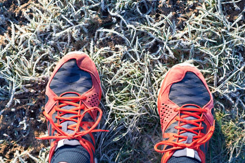 Preview: Overhead View Of Runners Feet Wearing Running Shoes On Frosty Grass