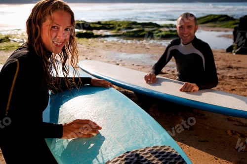 Preview: Couple Waxing Their Surfboards Smiling