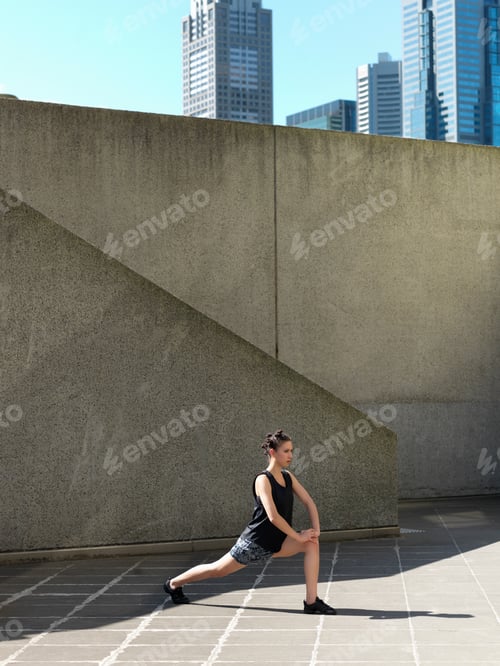 Preview: Young Woman Stretching In Front Of Concrete Wall, Melbourne, Victoria, Australia
