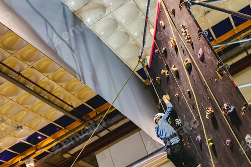 Preview: Boy Climbing A Climbing Wall To The Top To Overcome His Fears.